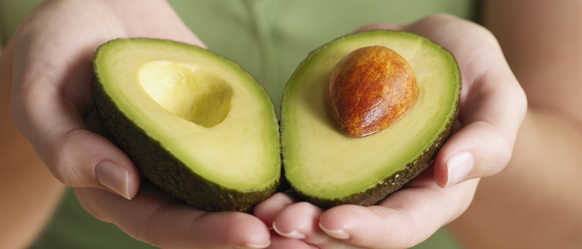 avocado halved in woman's hands