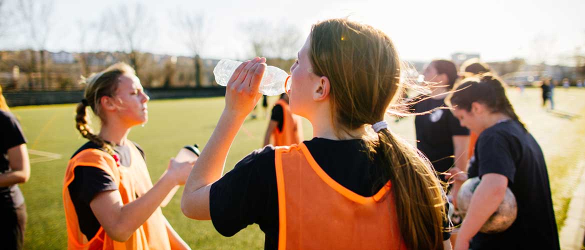 young women athletes drinking water during a match