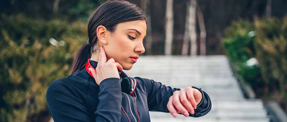 girl checking her pulse while on a run