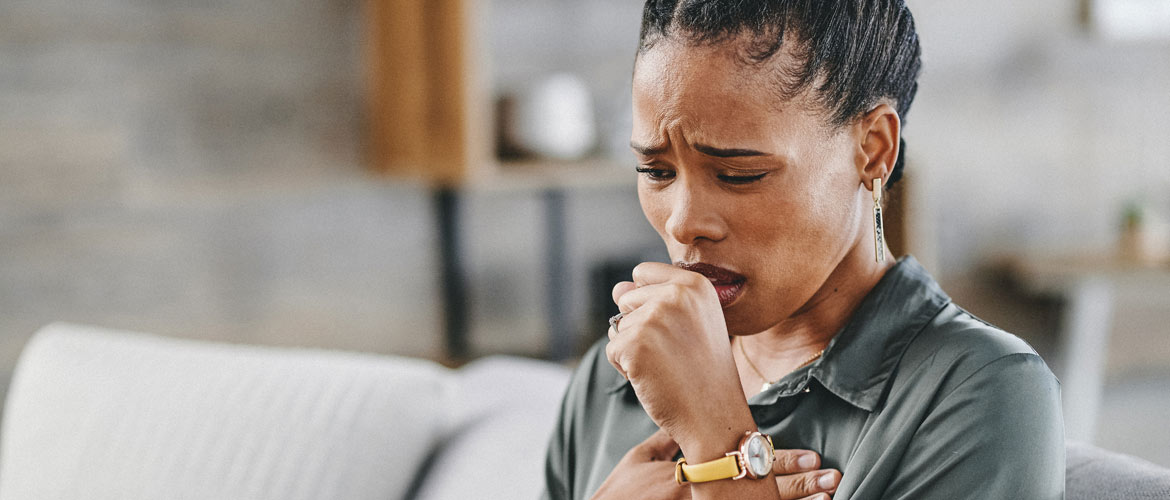 woman coughing on couch