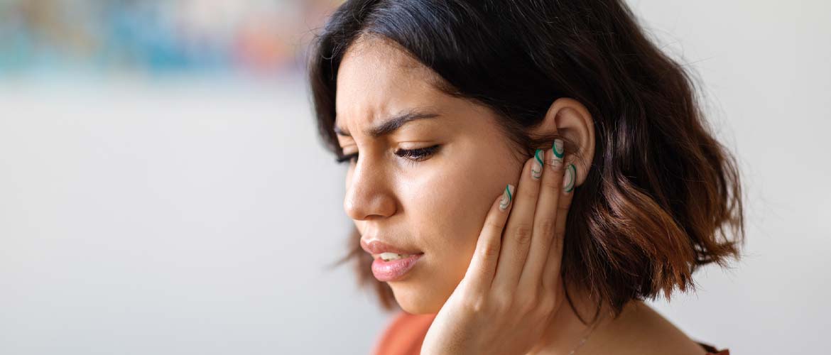 woman holding ear in pain