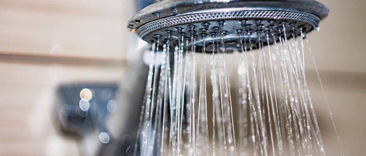 closeup of a shower head with water running