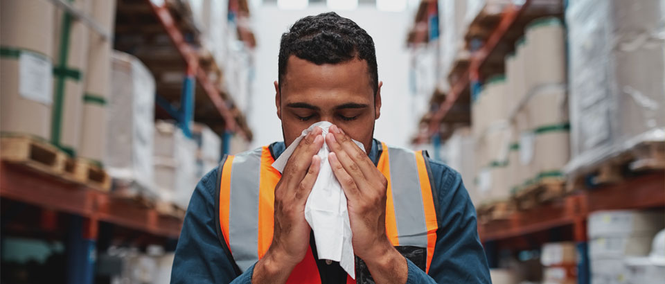 man blowing his nose into a tissue