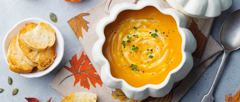 bowl of butternut squash soup sitting on a table