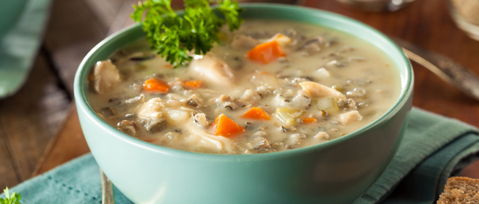 bowl of steaming chicken soup sitting on a counter