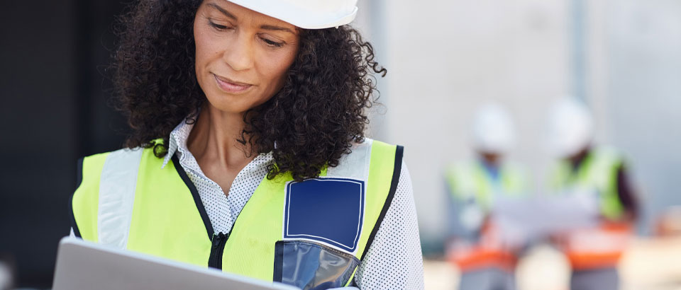 woman with a hard hat reviewing paperwork
