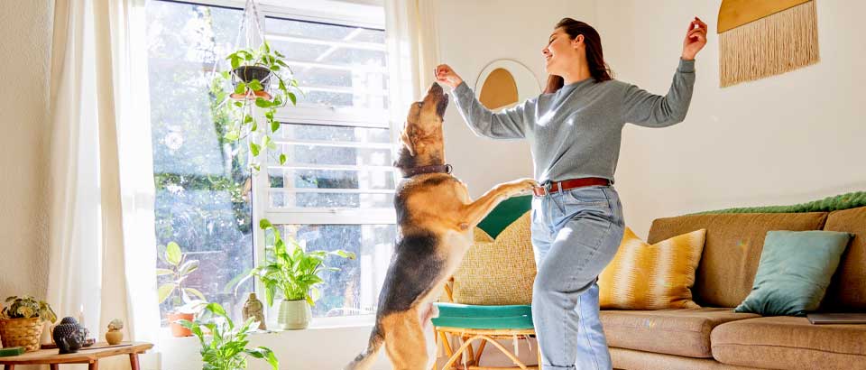 woman dancing next to window with sun coming in the room