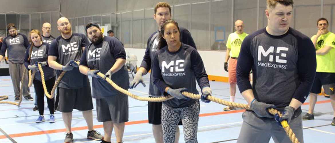 Arlene Neal and several other MedExpress employees participate in tug-of-war during a charity event