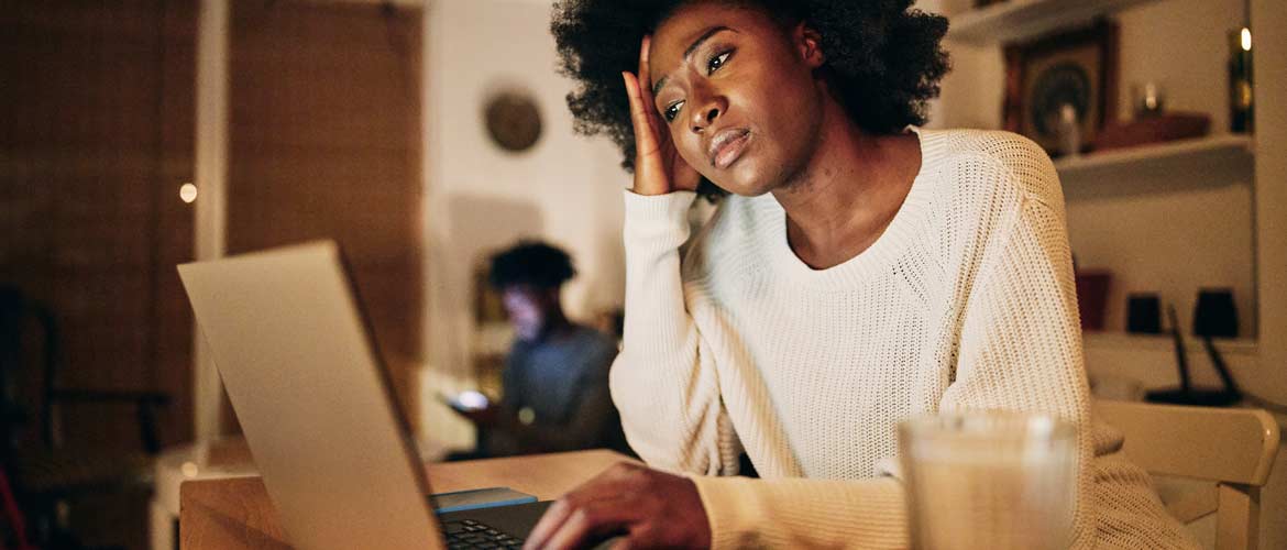 a woman looking burned out staring at her computer screen