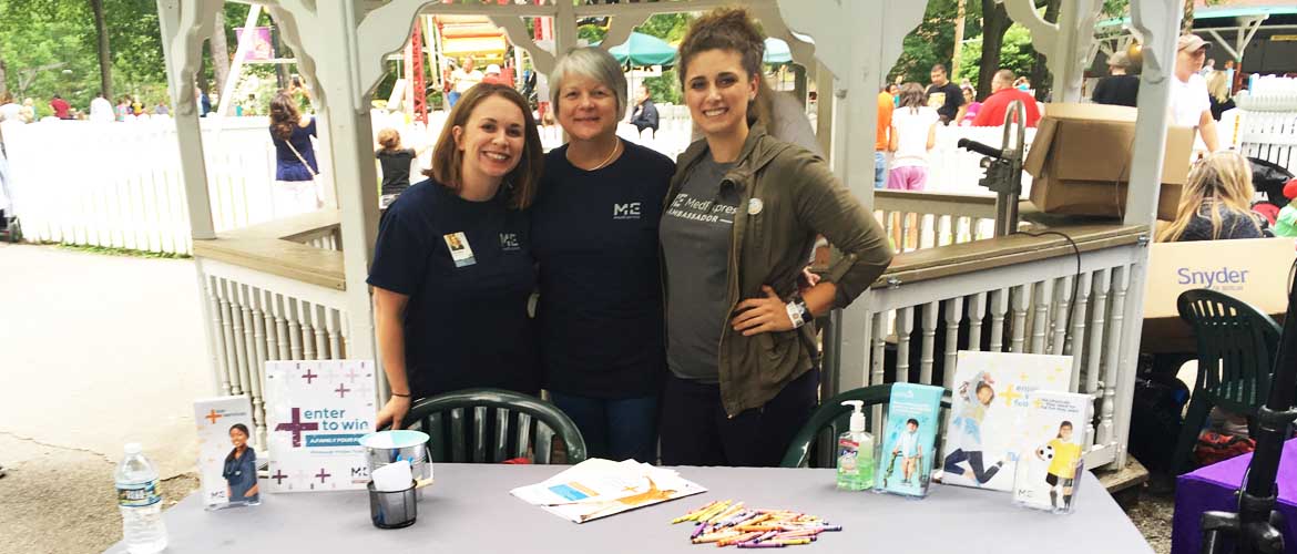 Three MedExpress employees at a table at Idlewild Park in Ligonier, Pennsylvania