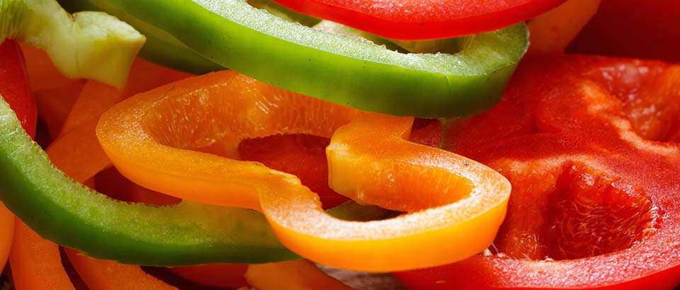 a pile of red, green, and yellow peppers