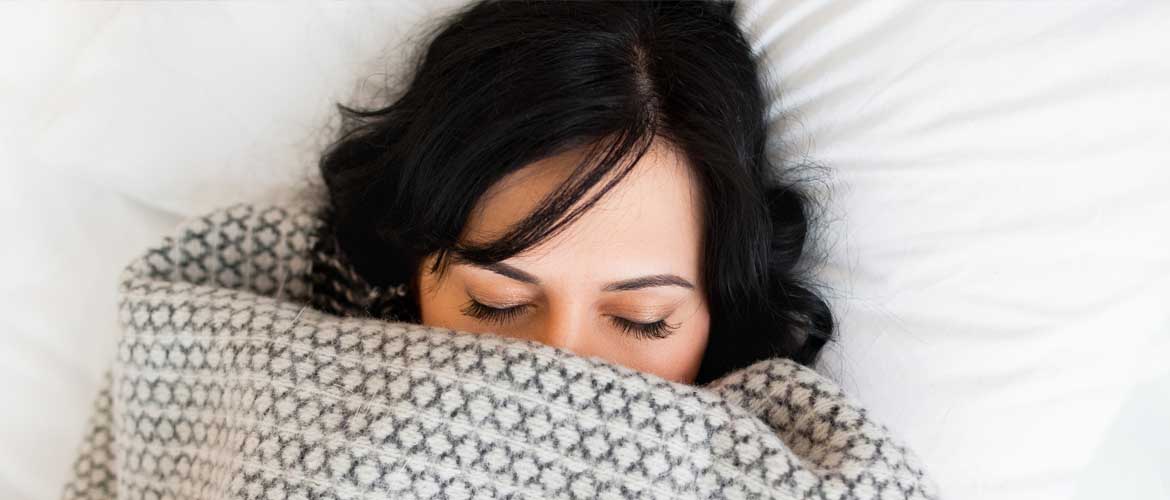 woman sleeping under blanket
