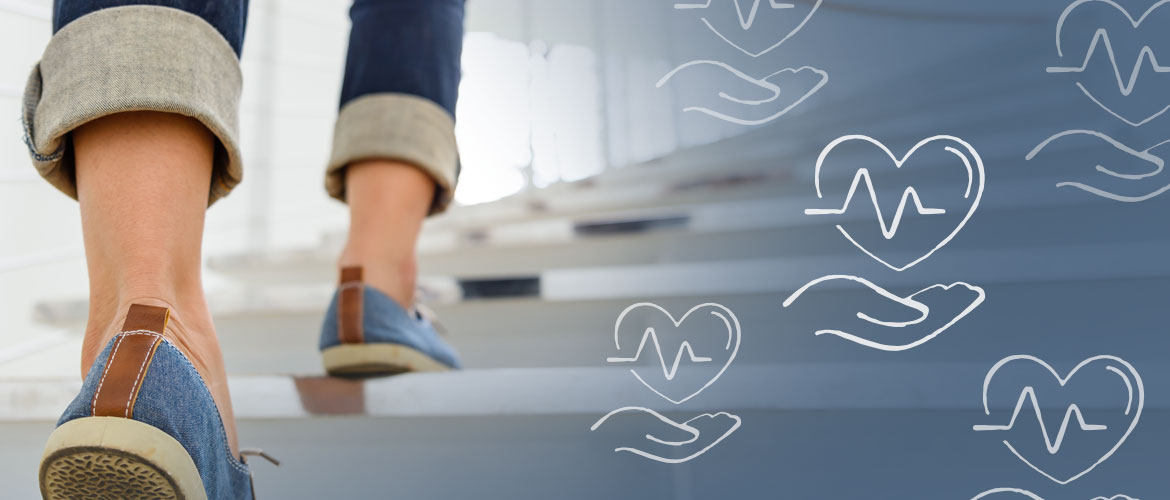 close-up of a person's shoes walking up a set of stairs with a hand underneath a heart icon overlaid on the image