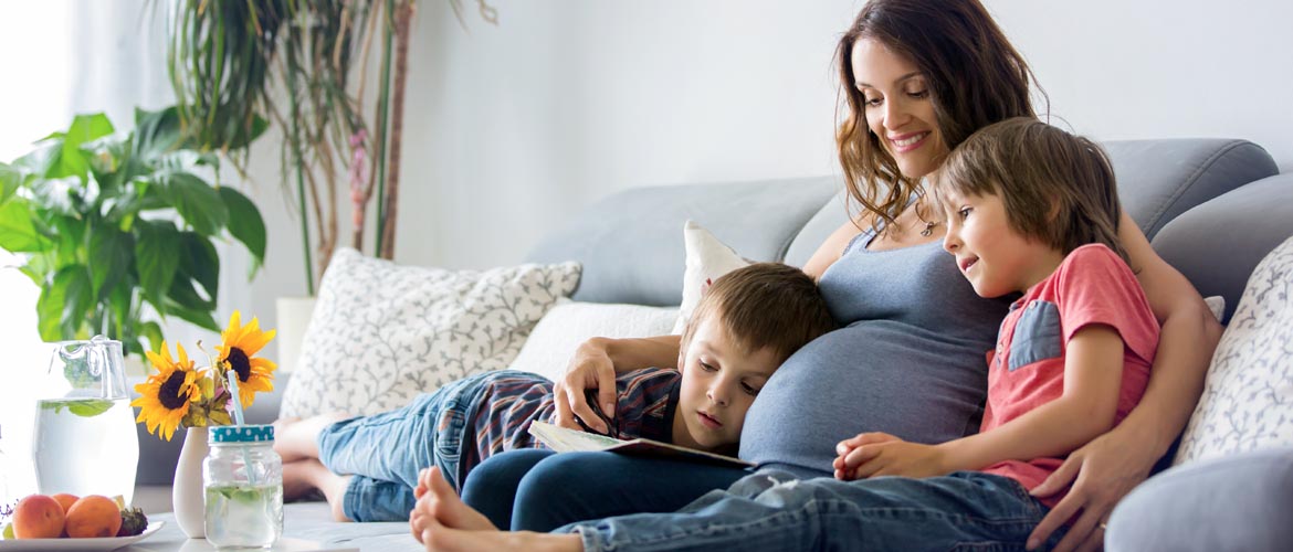 pregnant mother reading to her two children