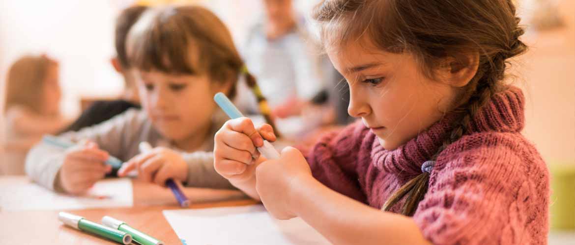 students drawing with markers in a classroom