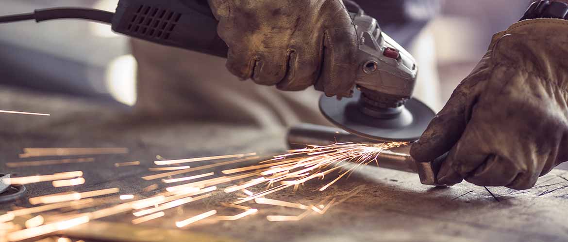 worker cutting iron with a saw, which is a high risk hand injury task