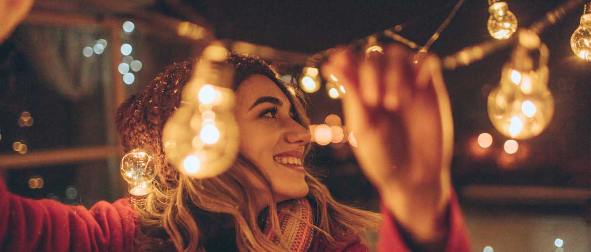 smiling woman hanging lights