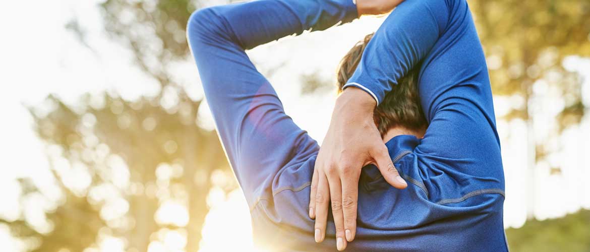 a runner stretching his arms behind his head