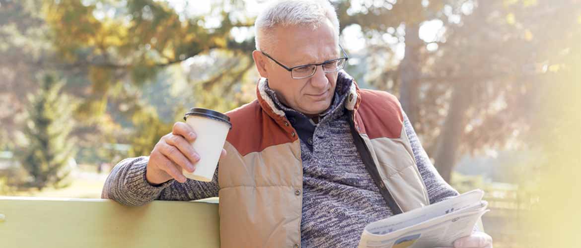 man drinking coffee and reading the paper