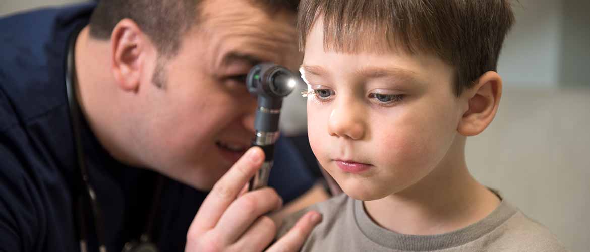 a MedExpress medical professional examining a young boy's ear