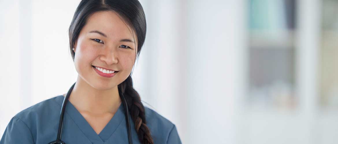 a smiling female medical professional dressed in scrubs with a stethoscope around her neck