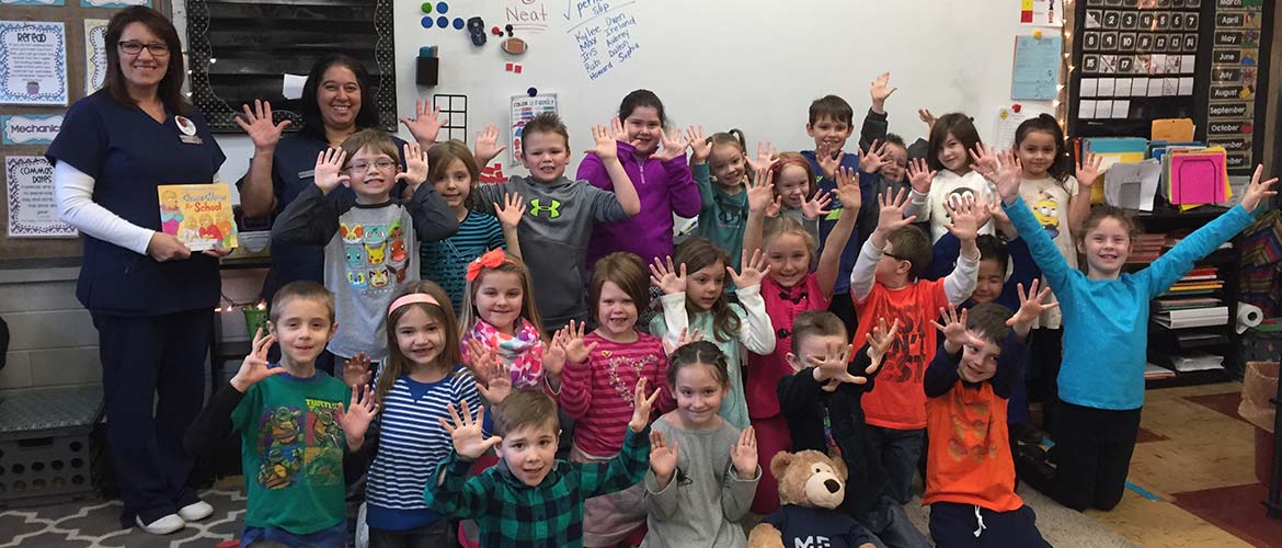 a group of young students holding up their hands