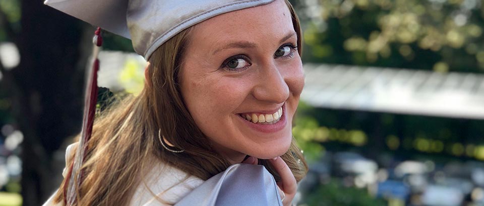 a photo of Kaitlin Berger wearing her graduation cap and gown