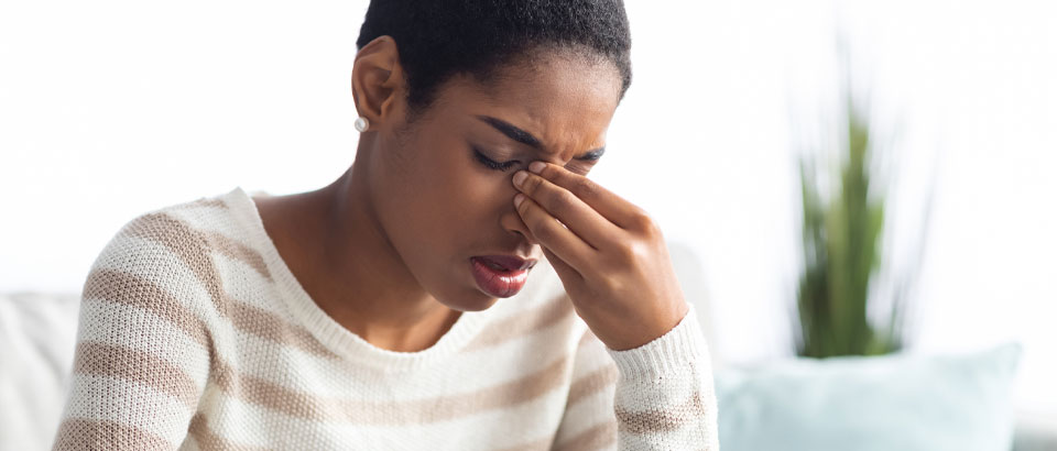 woman holding head suffering from sinus pressure