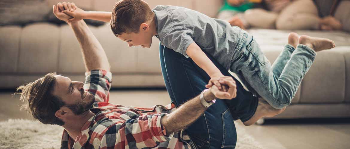 a father and son playing and having fun in their living room