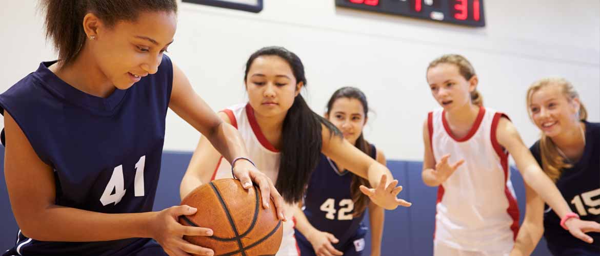 group of girls playing a basketball game