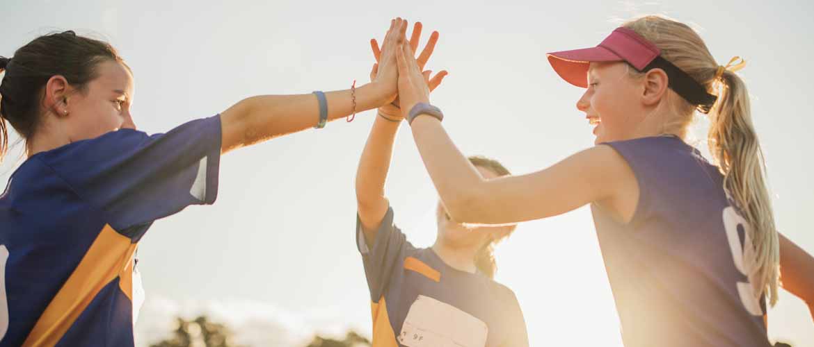 three girls high-fiving after a game