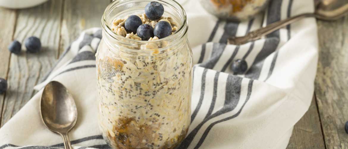 barattolo di vetro pieno di farina d'avena e mirtilli