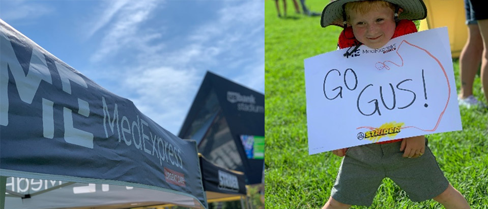 a MedExpress tent and a little boy holing a sign that says Go Gus