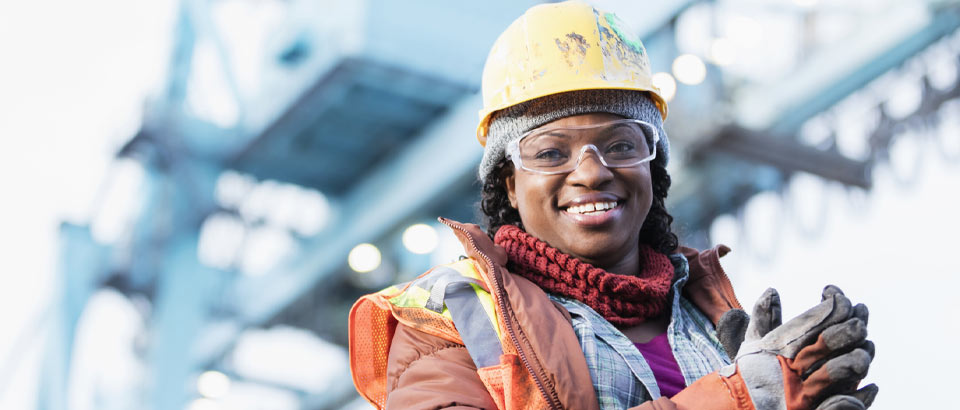 woman smiling and wearing a construction hat