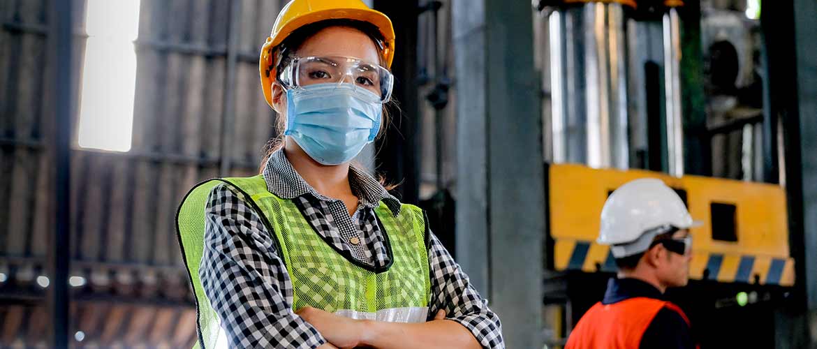 a warehouse employee wearing a hard hat and face mask