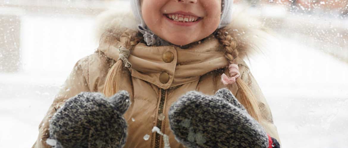 smiling child wearing mittens