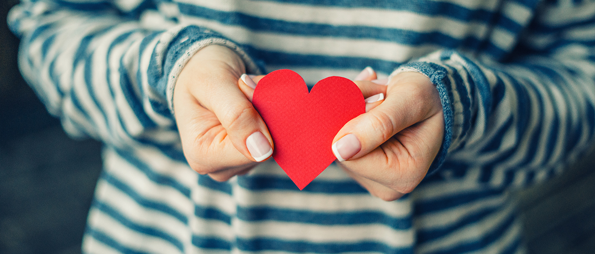 woman holding red paper heart