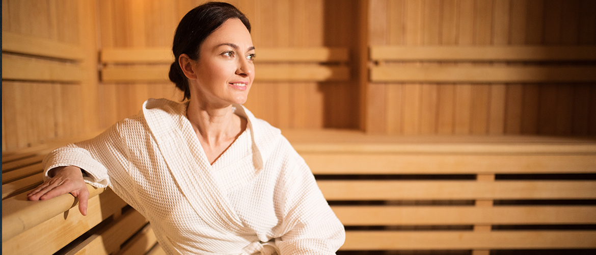 woman in robe sitting in sauna